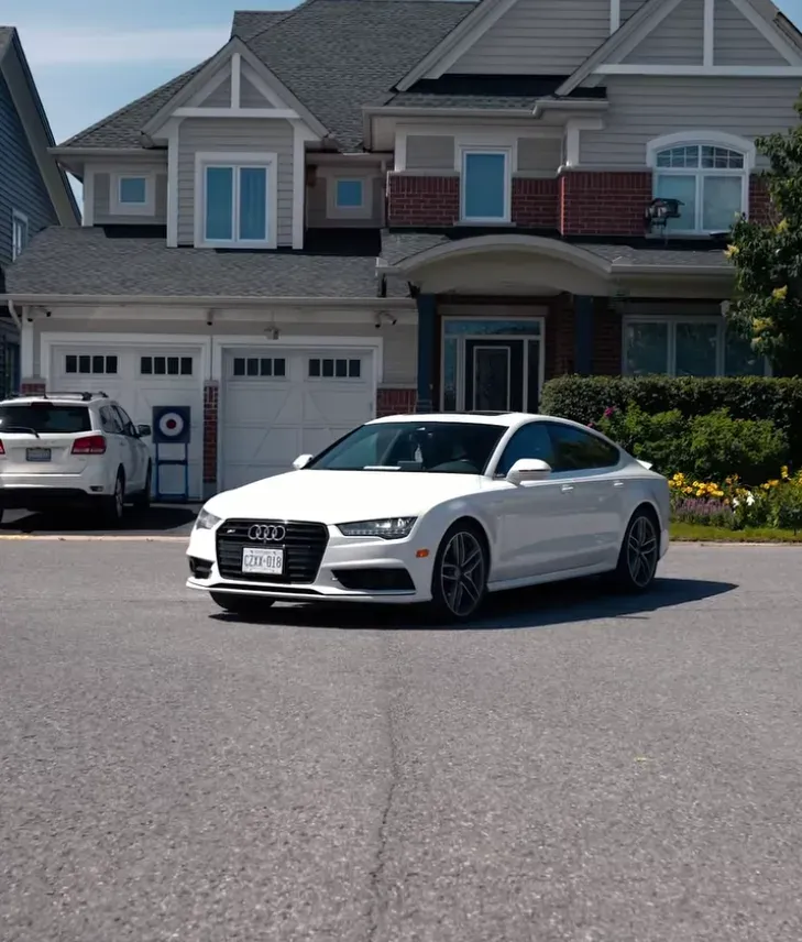 Tinted white Audi sedan parked in a residential suburban driveway